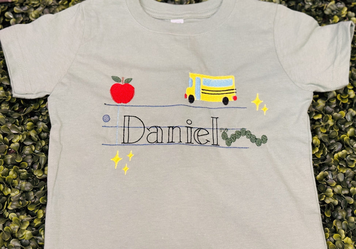 Gray children’s shirt personalized with Danielle and a school bus design