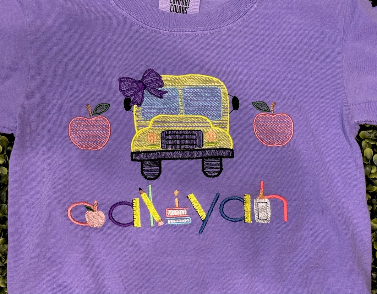 Purple children’s shirt with personalized school bus and apple embroidery