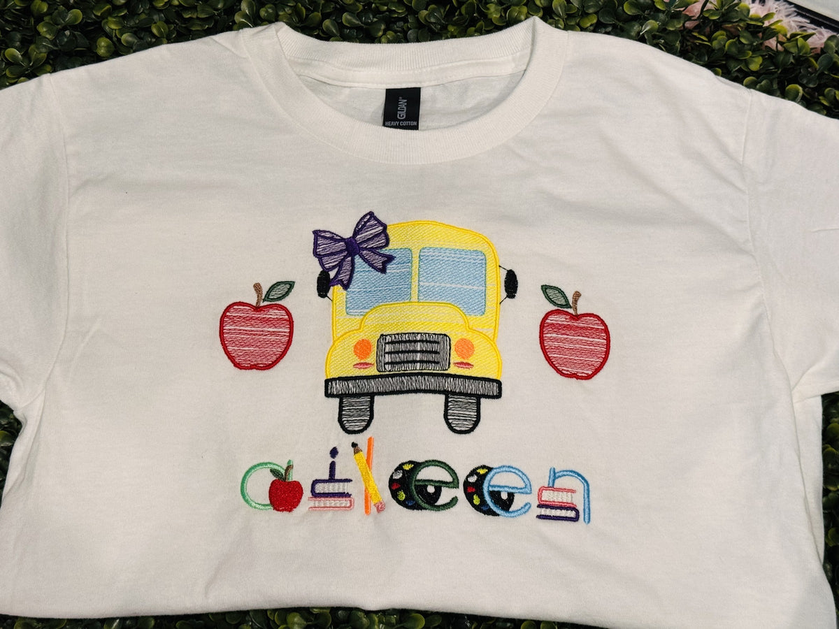 White children’s shirt with personalized school bus and apple embroidery