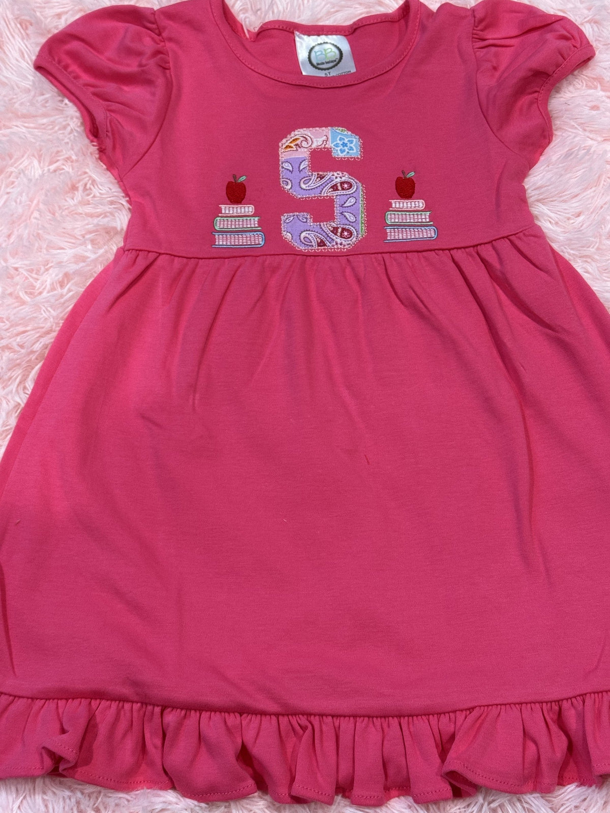 Pink ruffle dress with embroidered birthday number five and small cake motifs