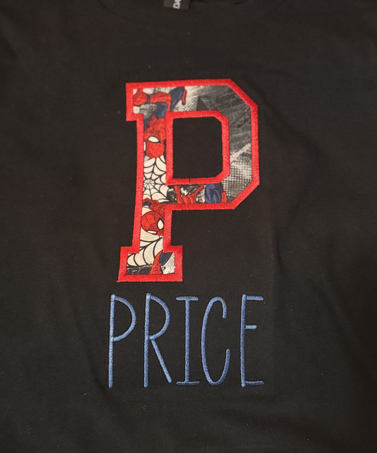 Dark fabric personalized with a large applique letter P and the name Price