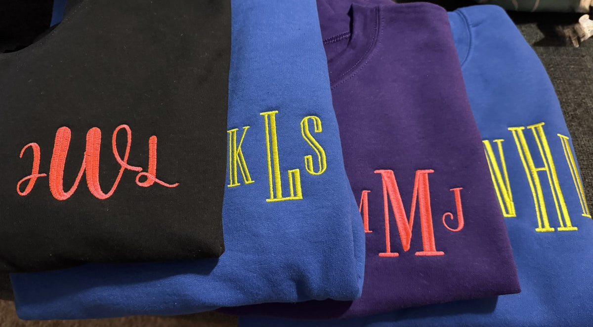 Group of dark and blue shirts with bright personalized initial monograms