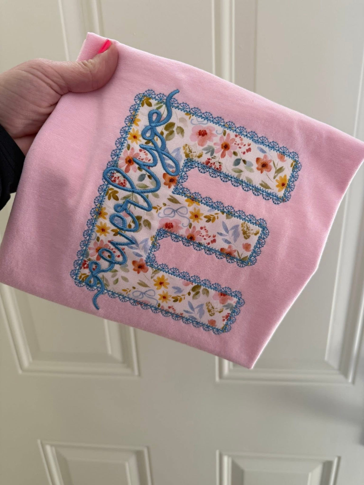 Pink shirt with large floral patterned letter E applique