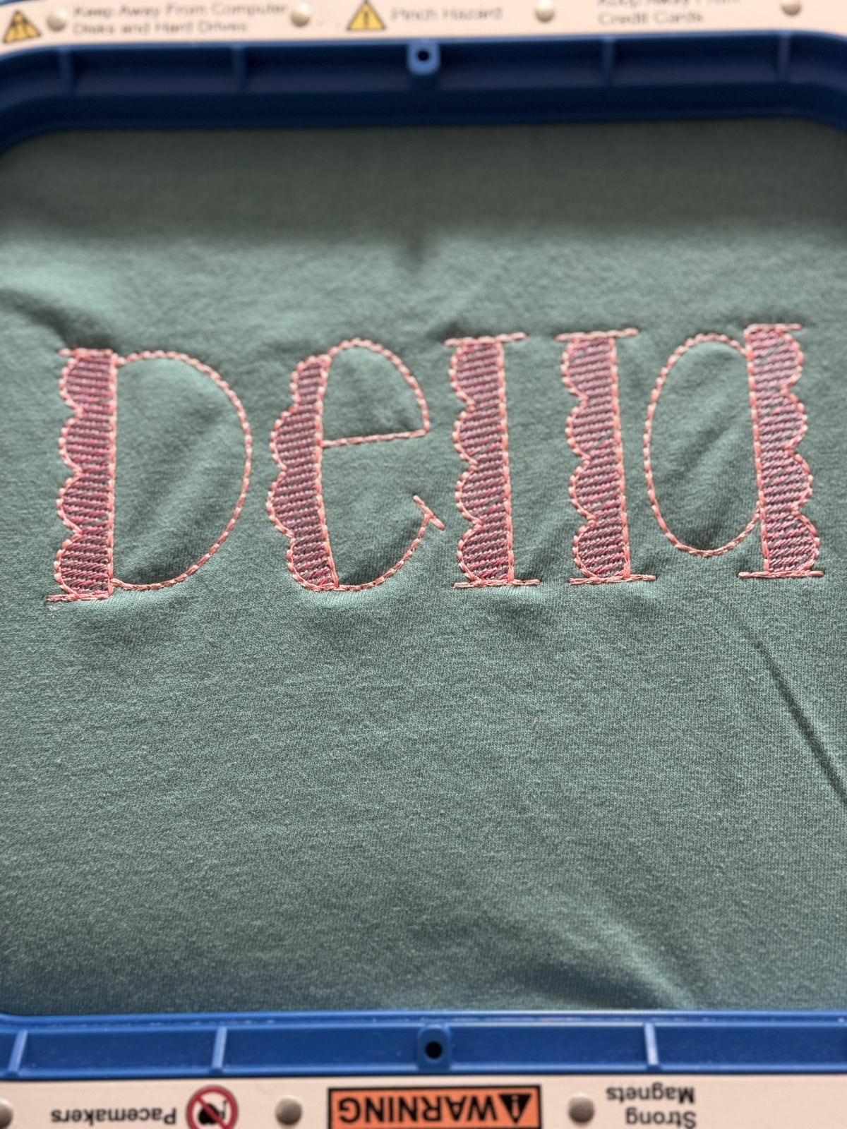 Teal fabric with large Della applique lettering in pink patterned fabric