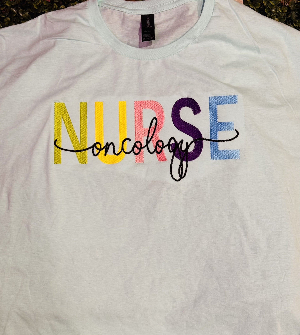 White shirt with colorful NURSE embroidery and personalized script name