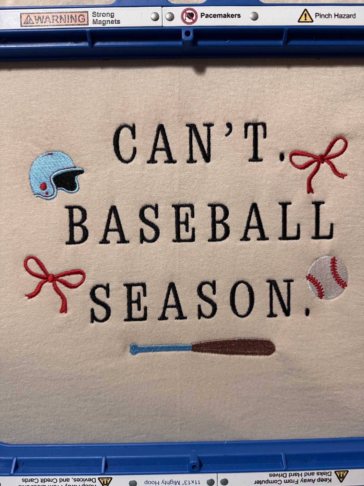 Cream fabric embroidered with Can’t Baseball Season and sports icon details