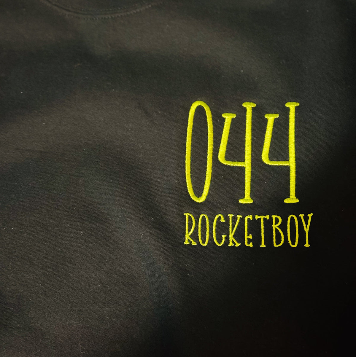 Dark shirt embroidered with number 044 and Rocketboy lettering