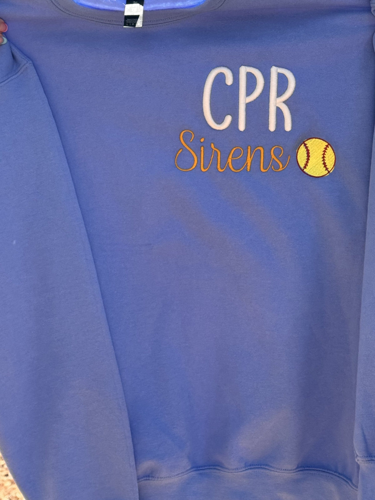 Purple team shirt embroidered with CPR Sirens and a softball detail