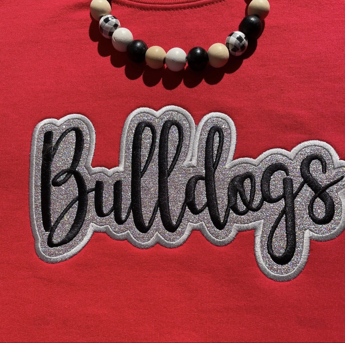 Red shirt with large Bulldogs applique embroidery and beaded accessory detail