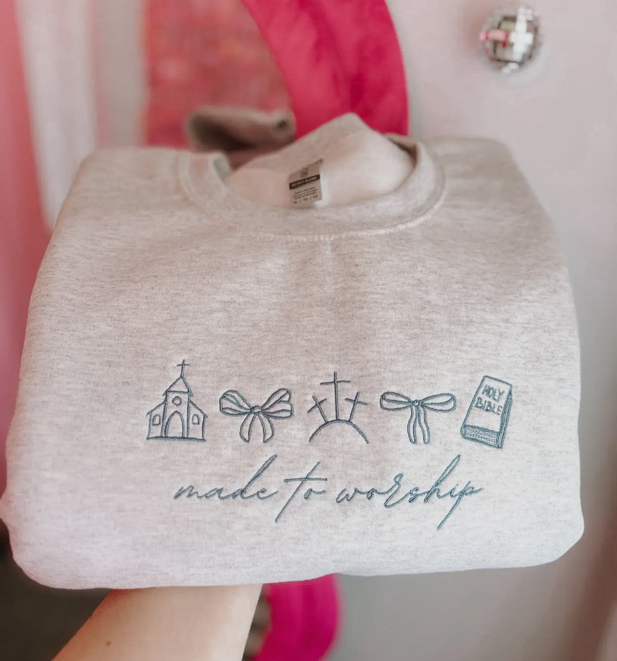 Cream sweatshirt embroidered with church, faith and worship icons and 'made to worship' text