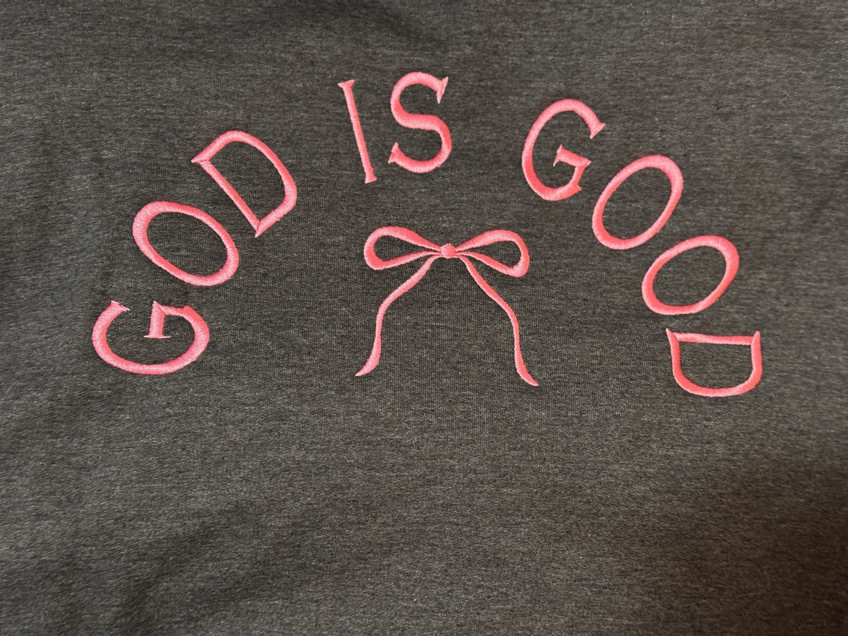 Dark sweatshirt with God Is Good embroidery and a small bow motif