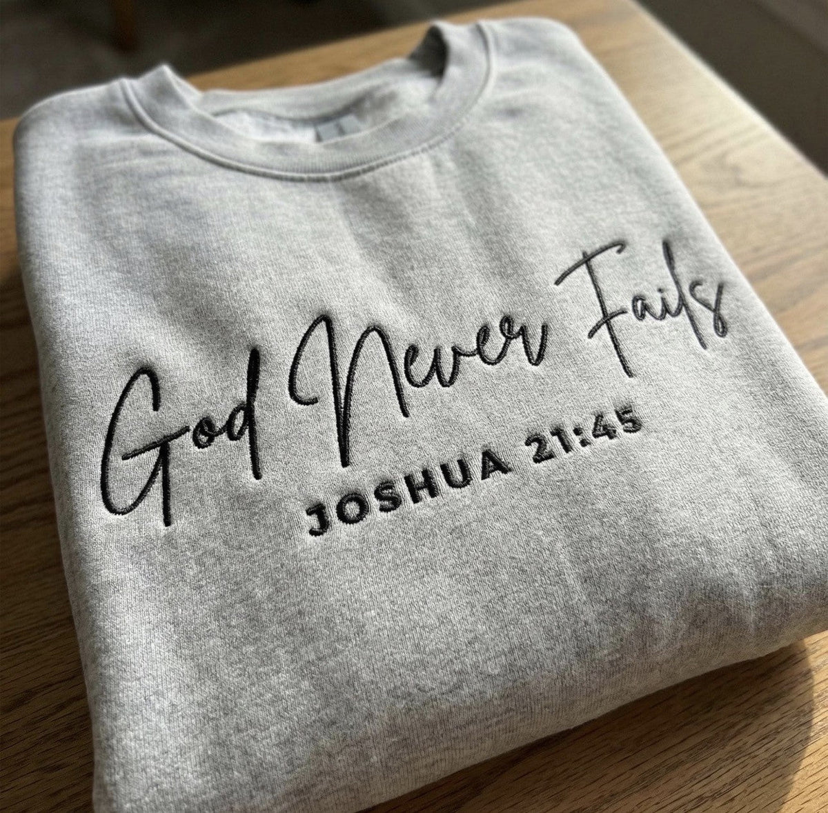 Gray sweatshirt embroidered with God Never Fails and Joshua 21:45