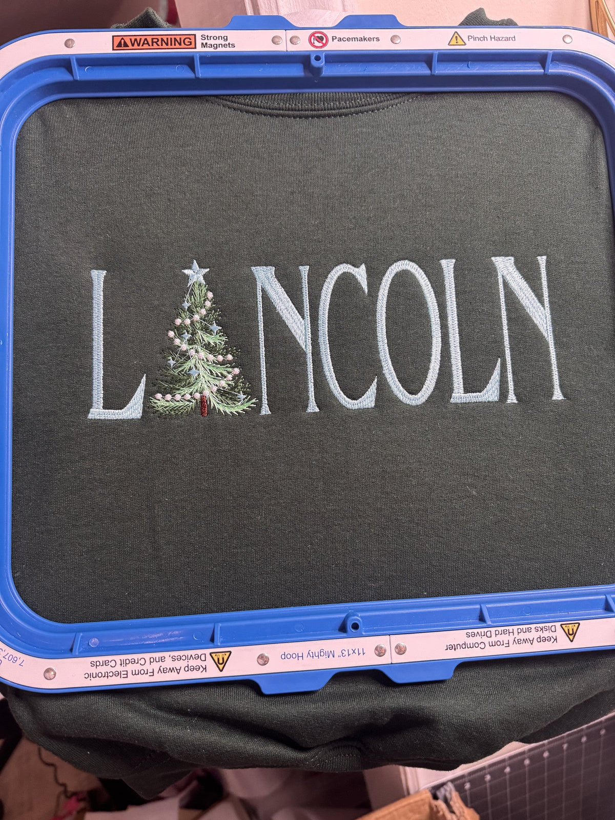 Dark shirt personalized with the name Lincoln and a Christmas tree letter detail