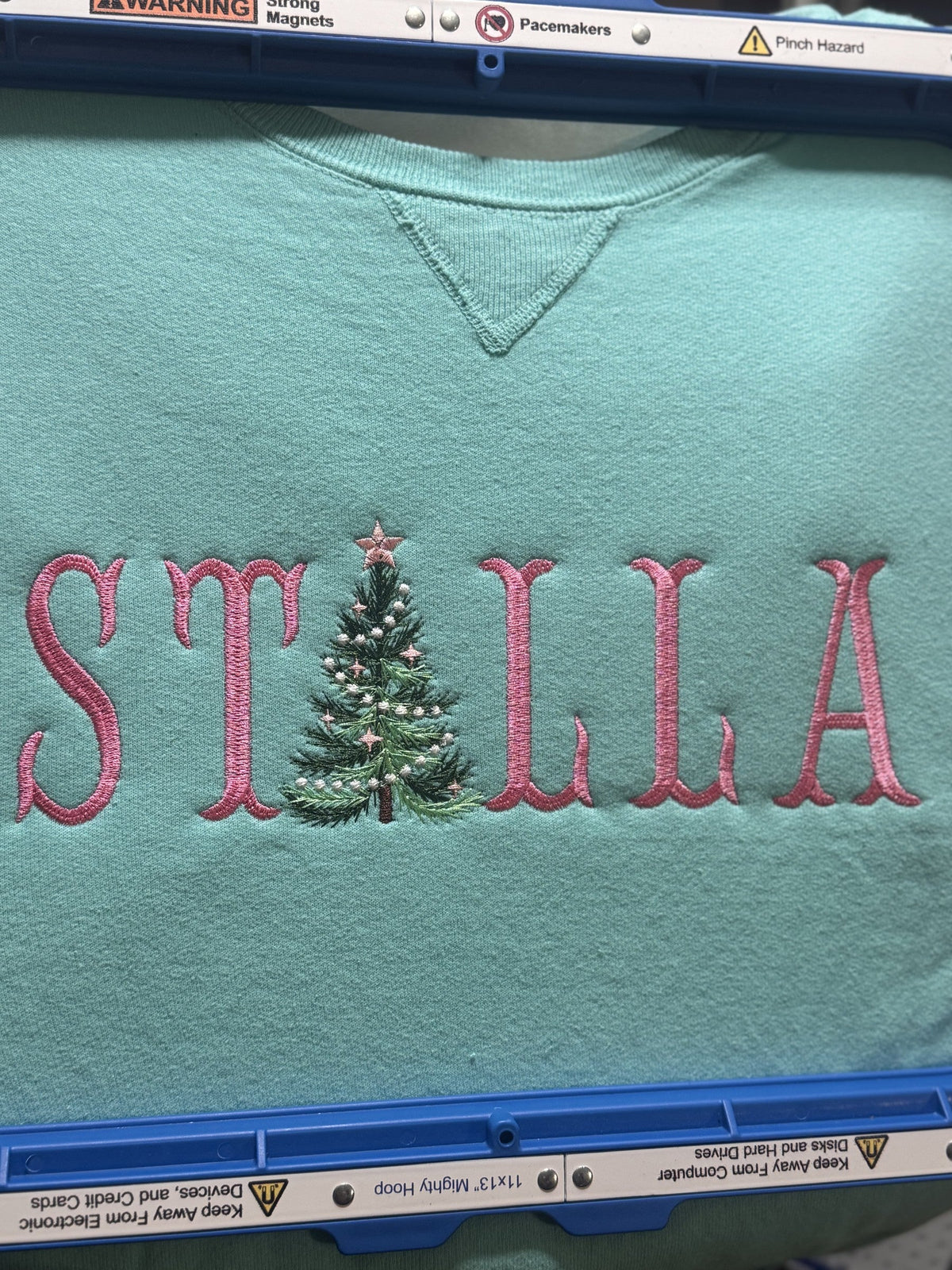 Teal shirt personalized with the name Stella and a Christmas tree letter detail