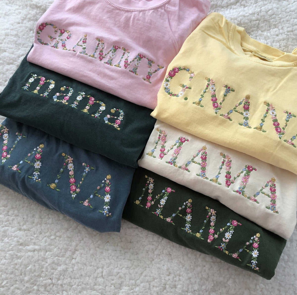 Assorted folded family sweatshirts with patterned applique lettering