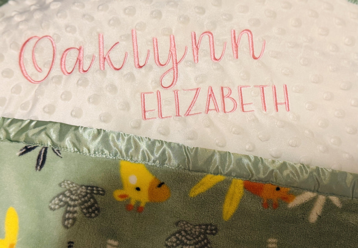 Soft baby blanket personalized with the name Oaklynn Elizabeth in pink embroidery