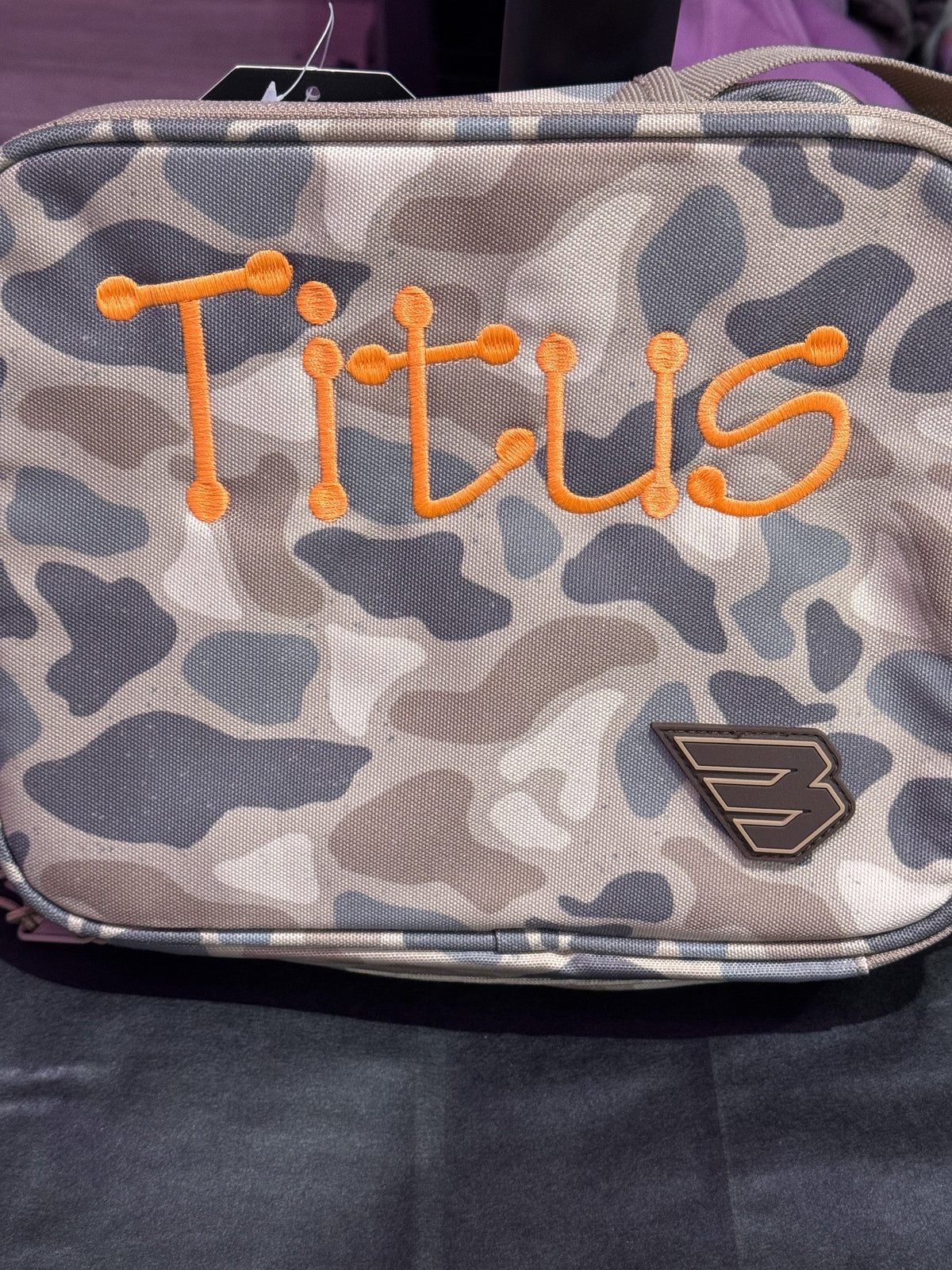 Close view of camouflage backpack personalized with the name Titus
