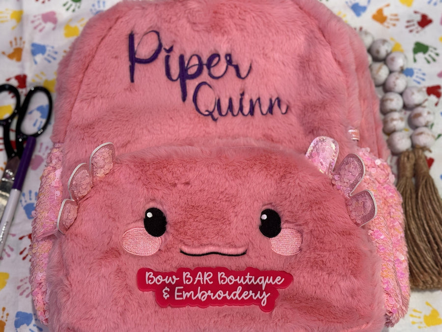 Pink axolotl backpack personalized with the name Piper Quinn